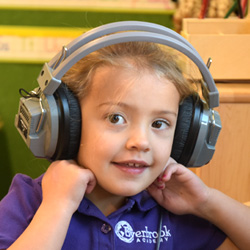 Preschool child wearing headphones during a listening activity