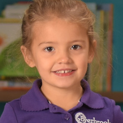 little girl with blonde hair in ponytail smiling