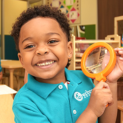 little boy with magnifying glass in his hands smiling