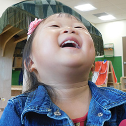 little girl laughing with her head back at daycare
