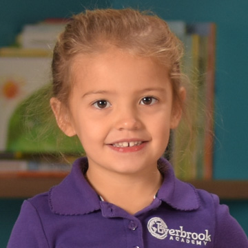 young girl smiling with hair in a ponytail 